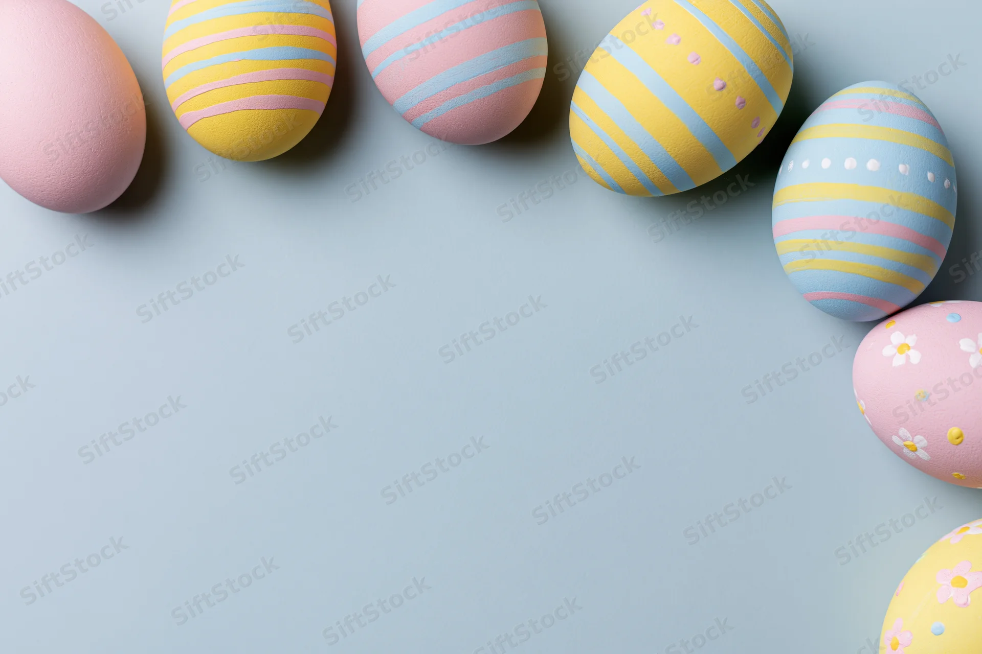Decorated easter eggs arranged along the top and right edge of a light blue surface with copyspace