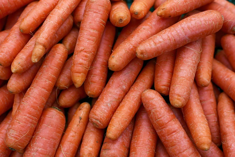 A pile of fresh whole carrots filling the frame