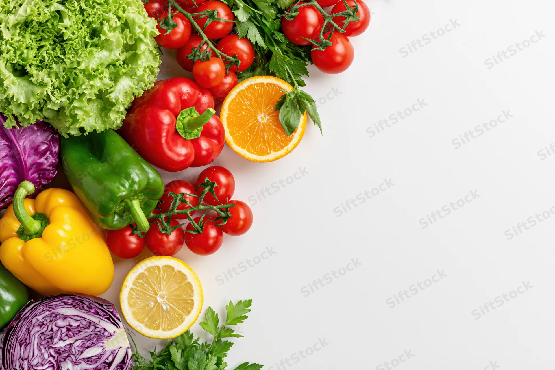 Fresh vegetables and fruits arranged loosely in the corner on white background with copyspace