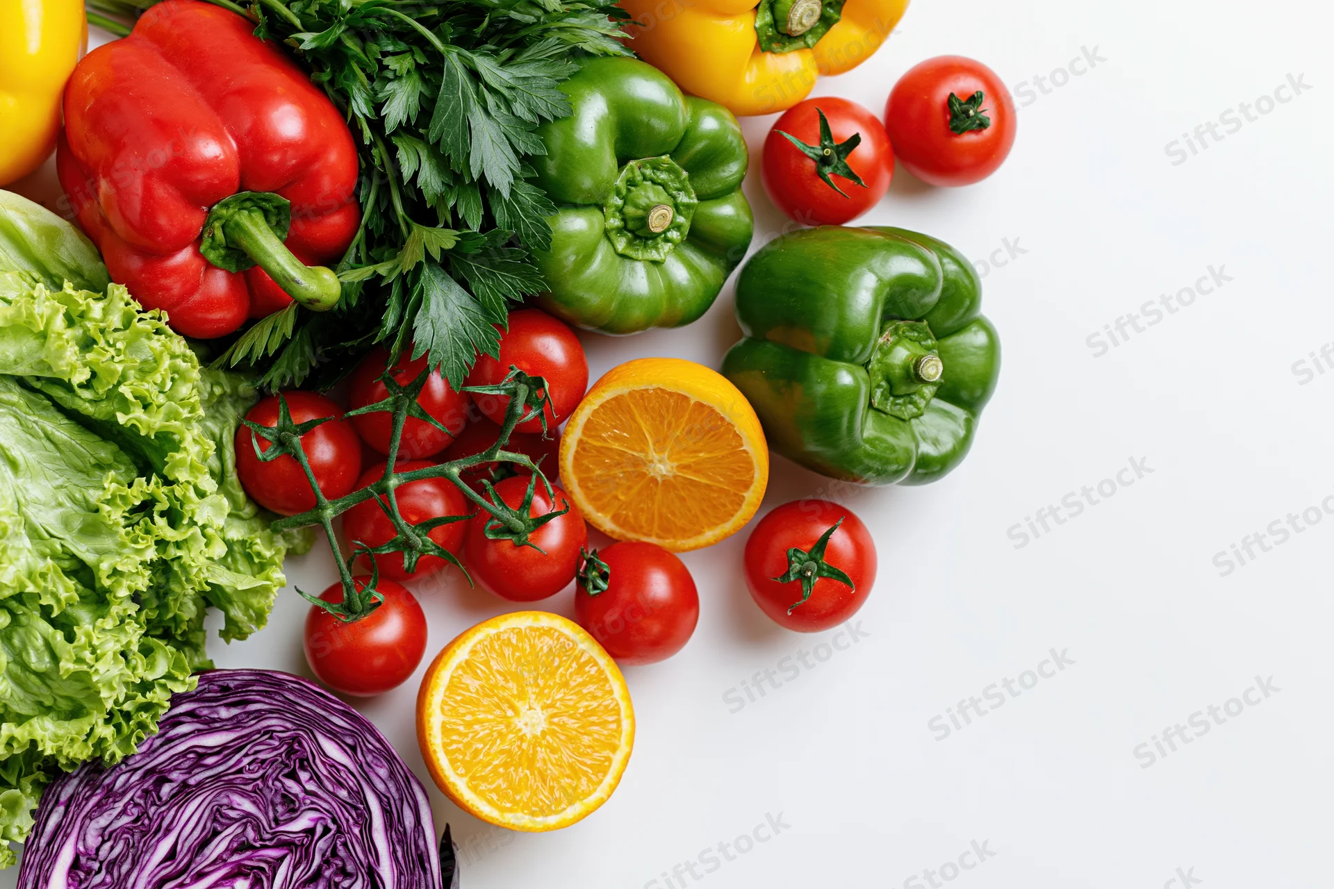 Fresh vegetables and fruits arranged loosely on white background with copyspace