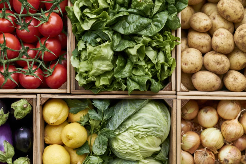 Fresh vegetables arranged in wooden crates at market display
