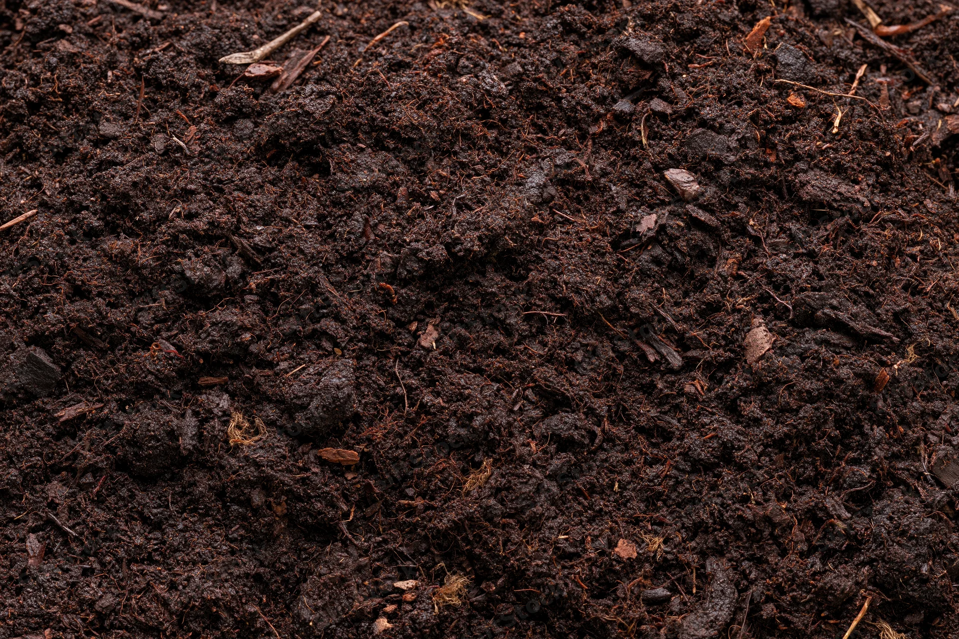 Dark organic compost soil filling the frame in a flat lay view