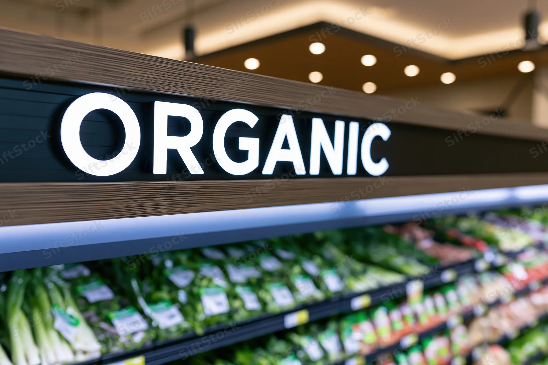 Illuminated organic sign above refrigerated produce shelves in a grocery store