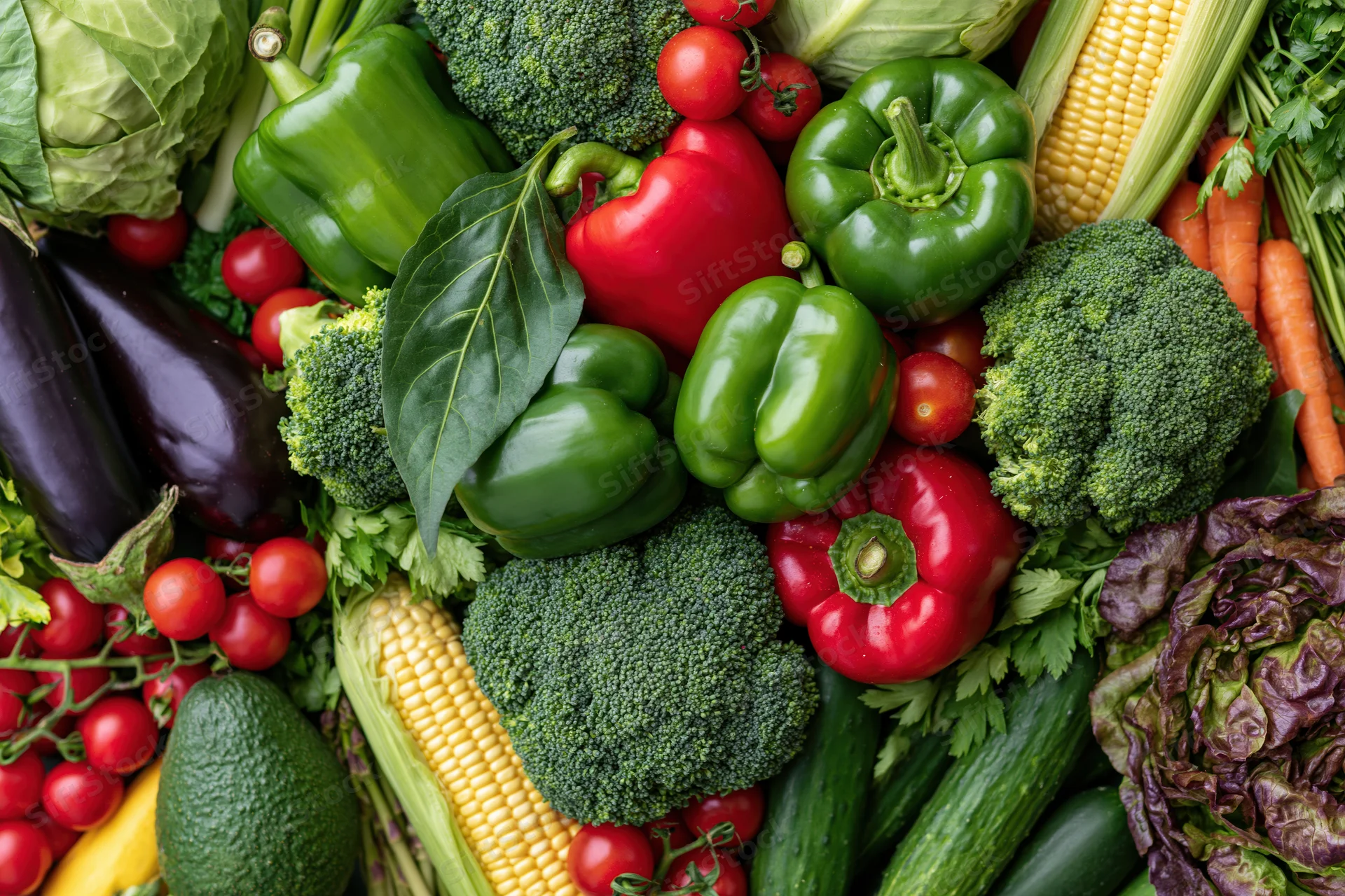 Overhead flat lay of fresh vegetables arranged densely on a surface