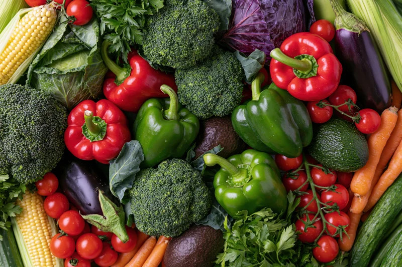 Overhead flat lay of fresh vegetables arranged densely on a surface