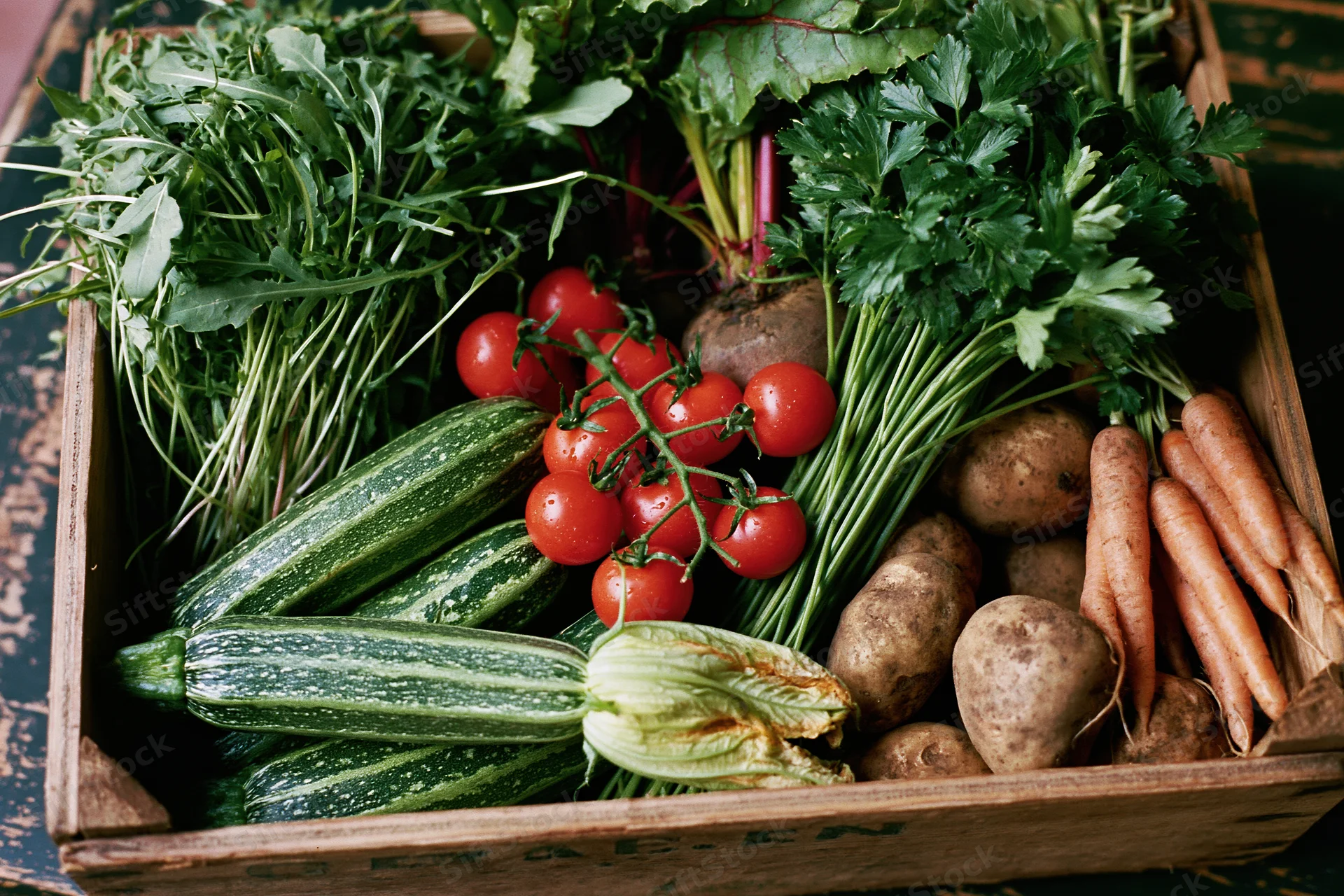 Wooden crate filled with freshly harvested vegetables arranged in rows