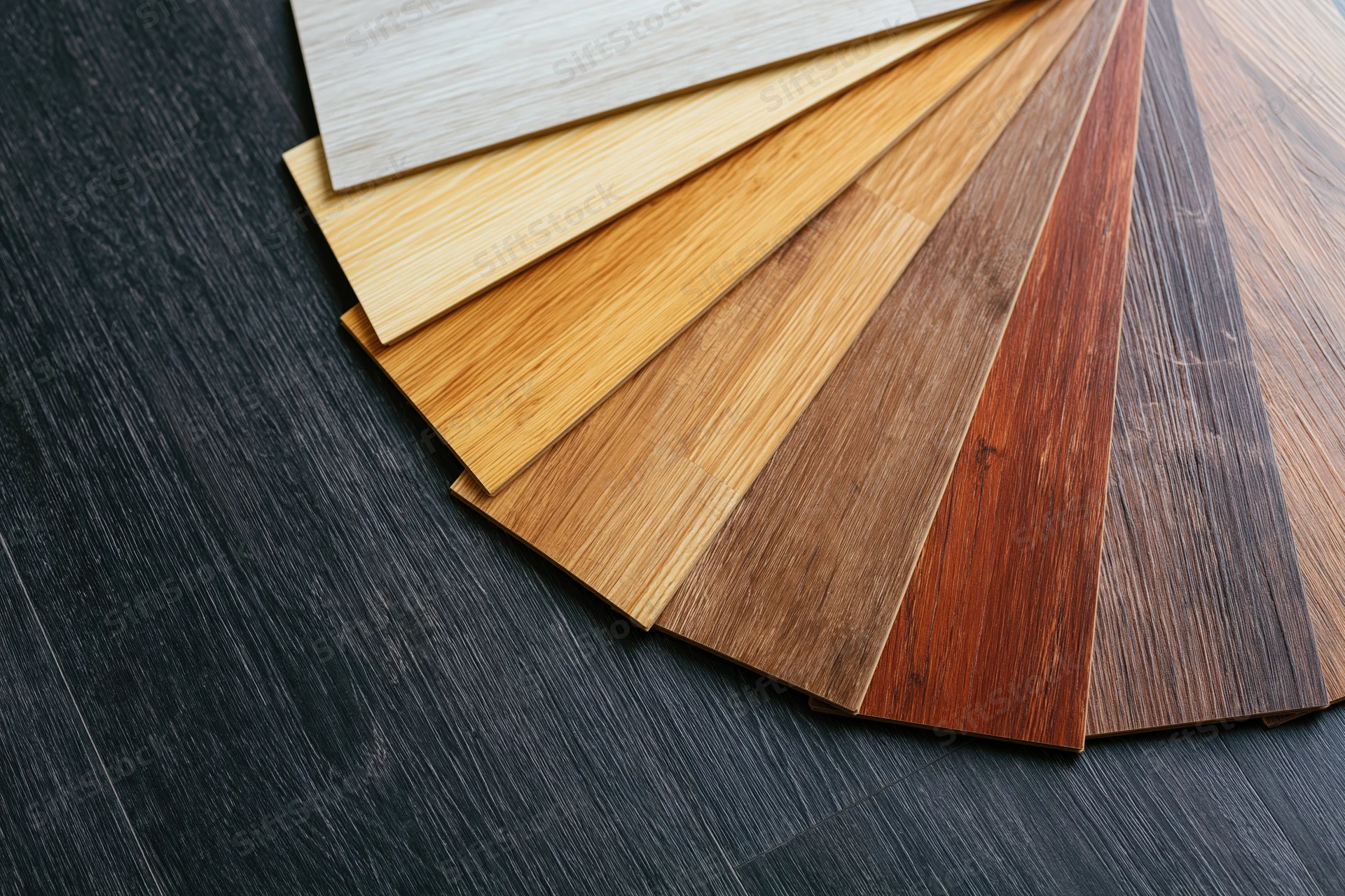 Fan arrangement of wood flooring laminate samples on dark surface