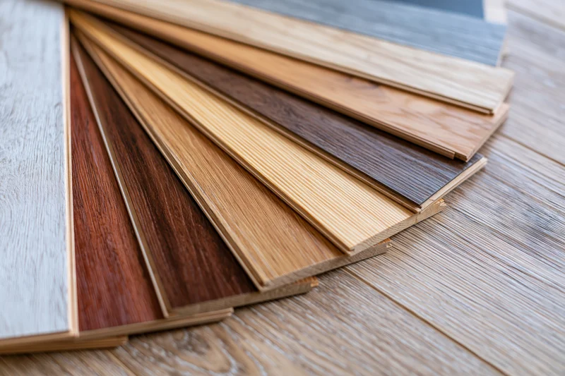 Wood flooring sample boards fanned out in overlapping arrangement on wooden surface