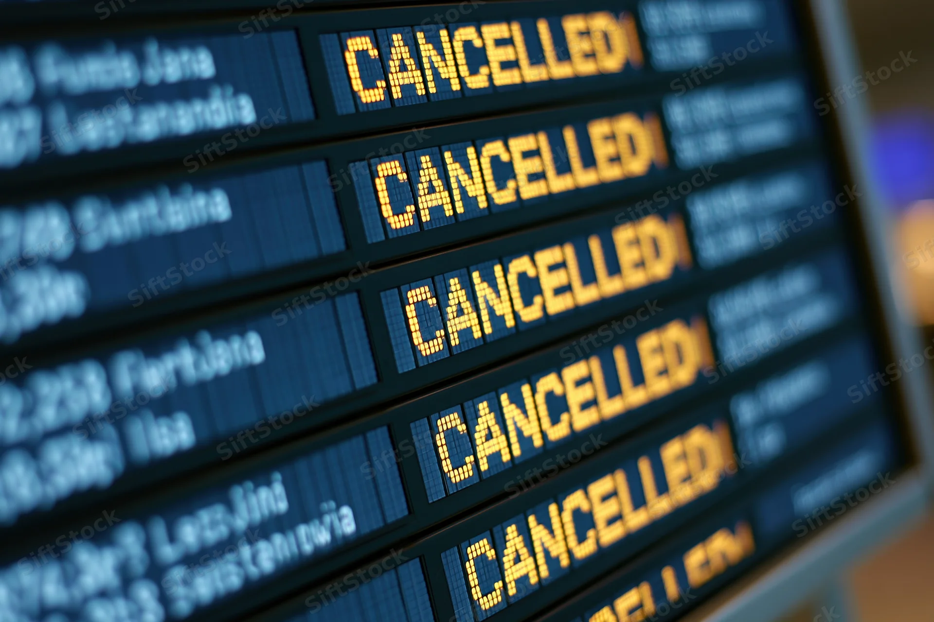 Digital airport departure board showing multiple cancelled flights in yellow text on blue background