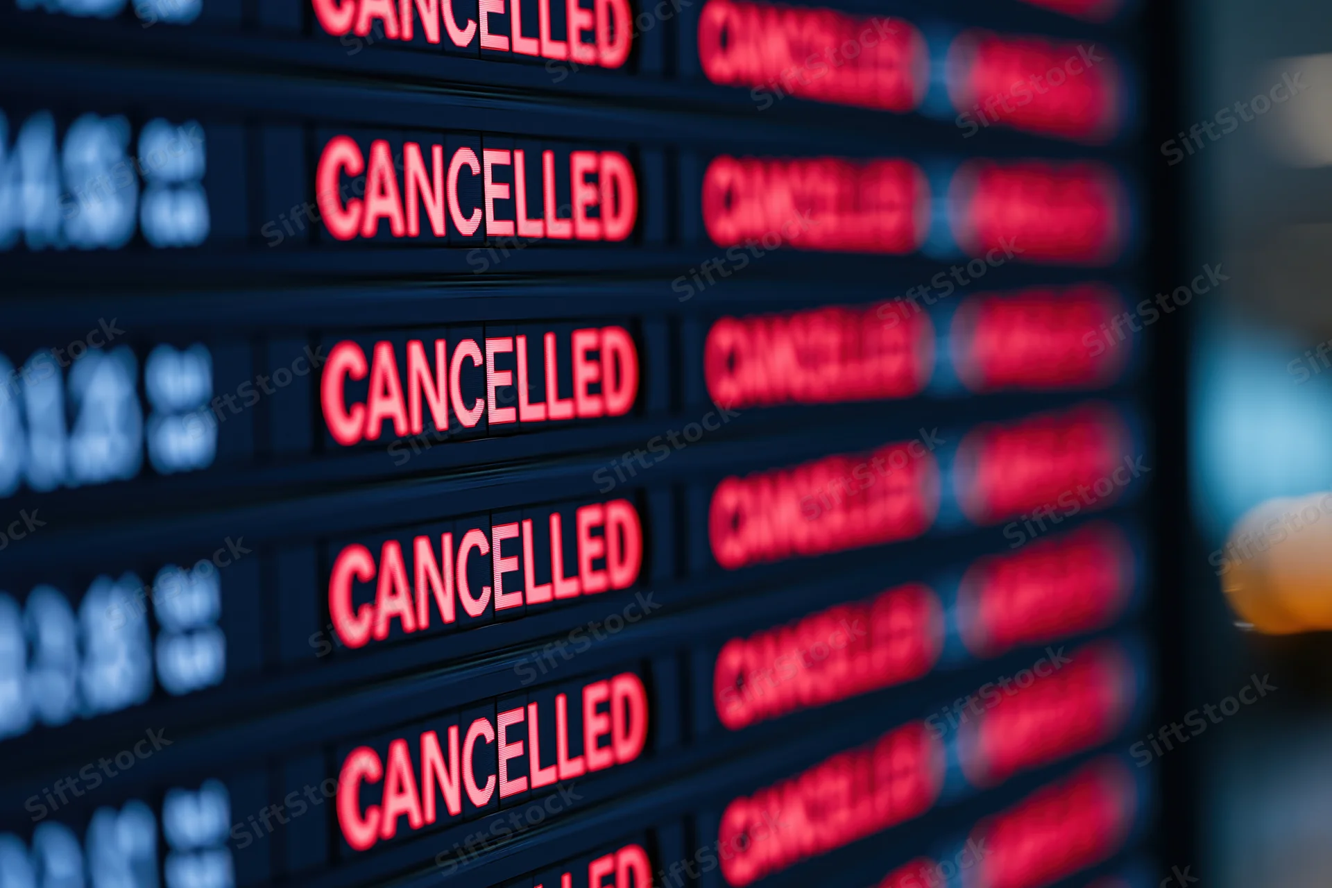Digital departure board showing multiple cancelled flights in red text at airport terminal
