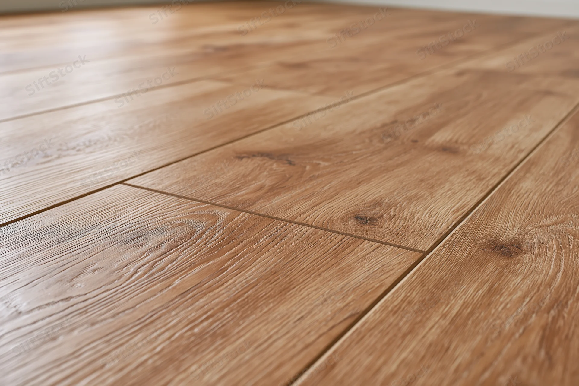 Medium oak laminate flooring planks arranged in diagonal pattern on interior floor
