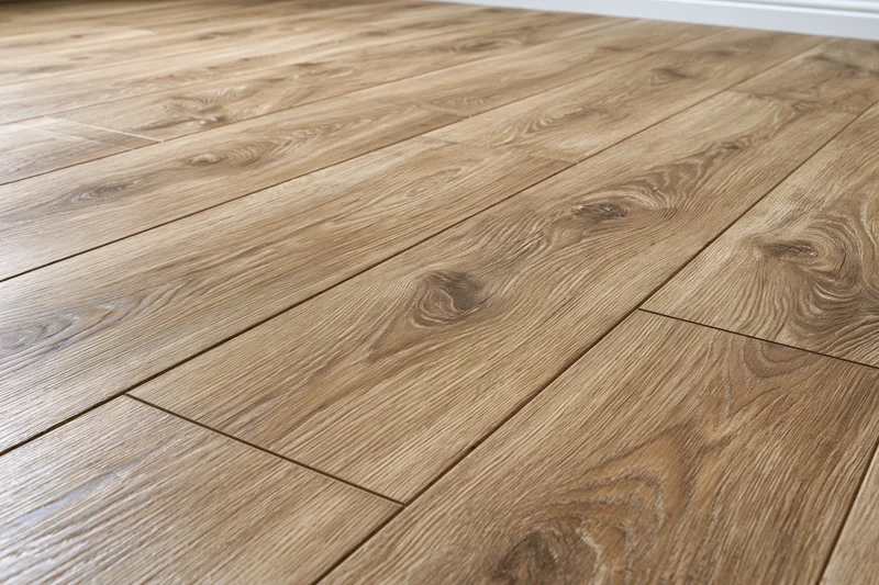 Close-up angled view of medium oak laminate flooring planks arranged in a staggered pattern on an interior floor