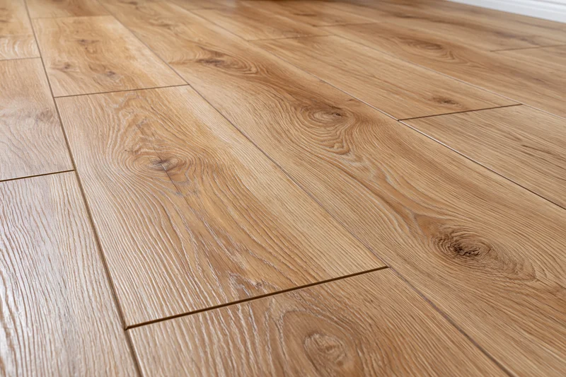 Medium oak laminate flooring planks arranged in staggered pattern on interior floor