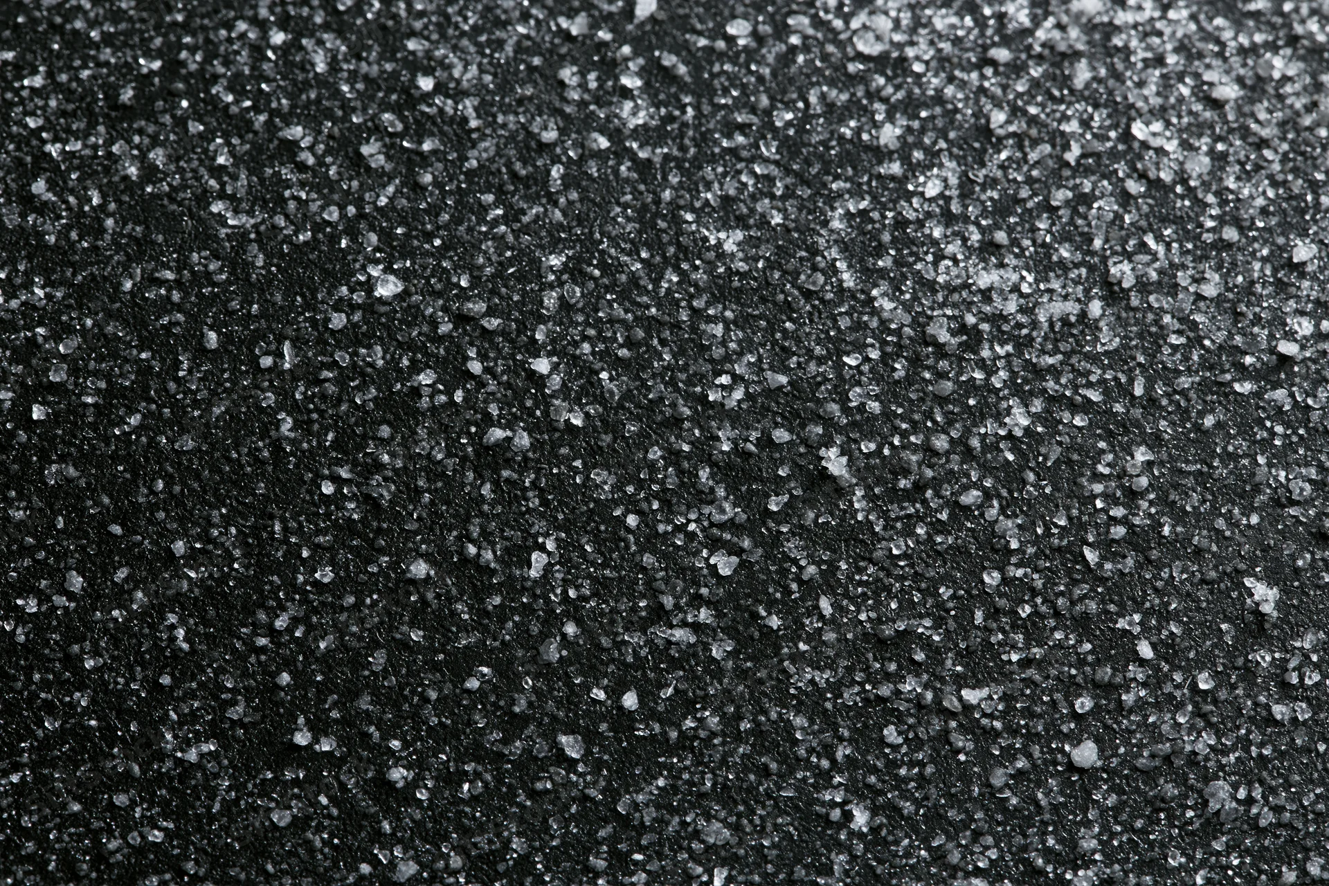 Close-up of dark matte black surface covered in fine crystalline particles arranged flatly