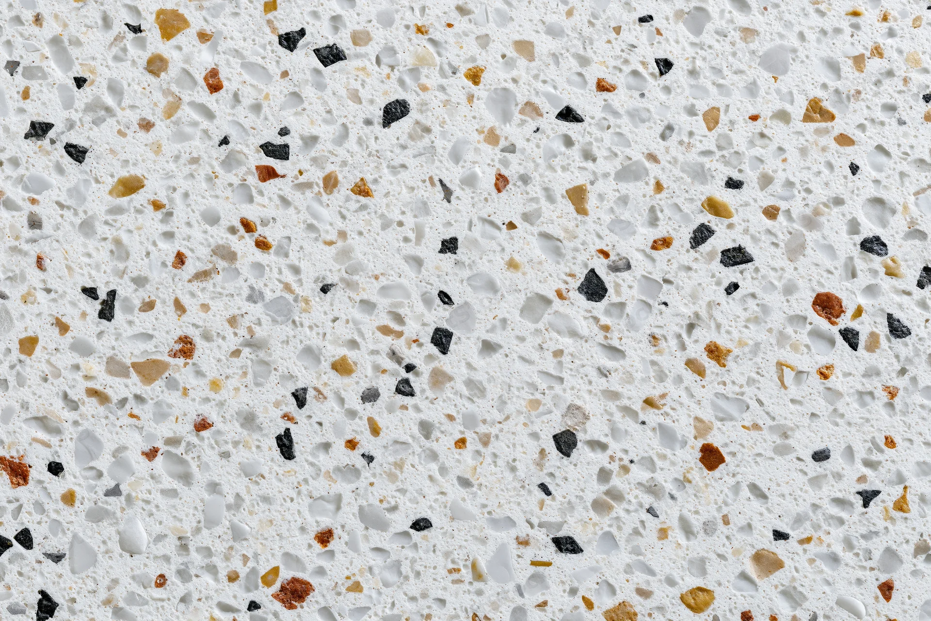 Polished terrazzo floor surface with embedded stone aggregate in white and earth tones, flat lay close-up