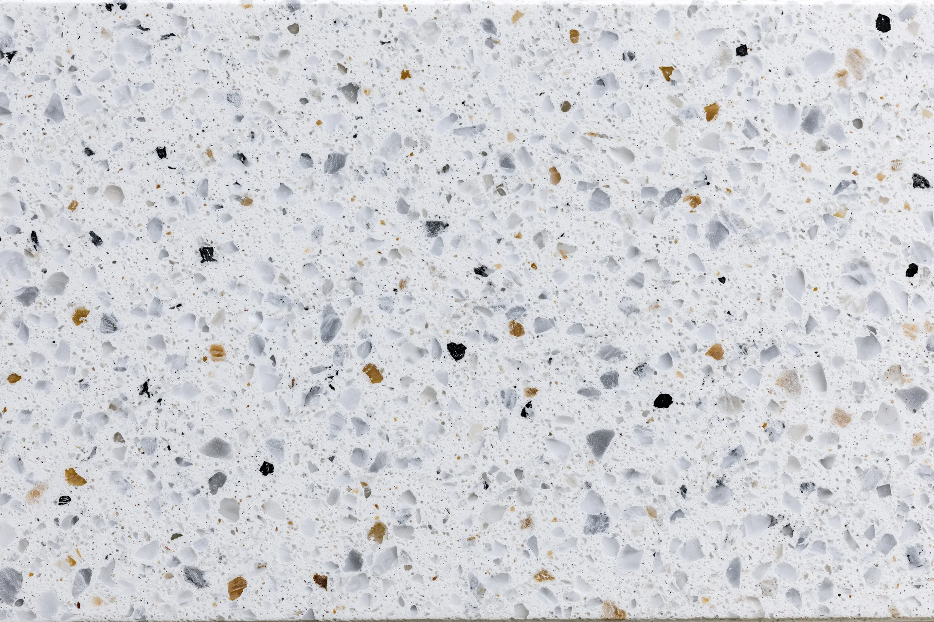 Polished terrazzo surface with white base and multicolored aggregate speckles filling the frame