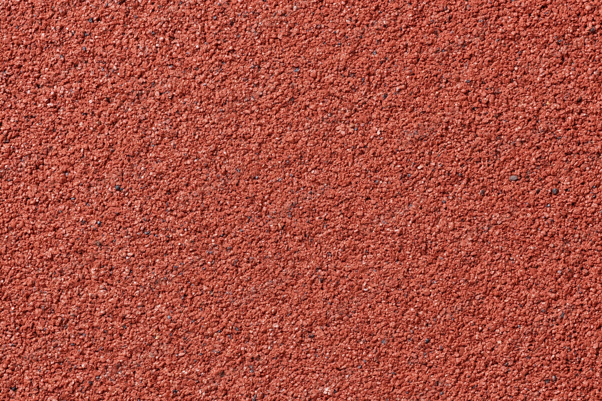 Close-up flat lay of a red rubber running track surface filling the frame