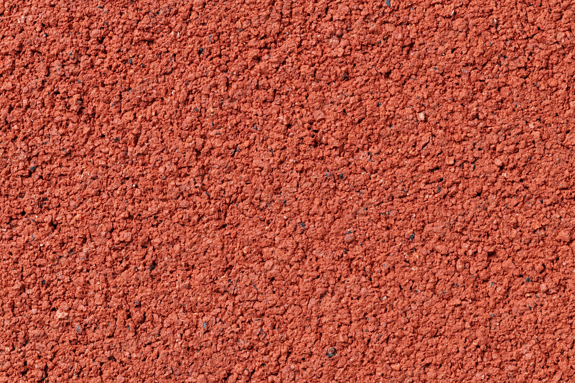 Close-up flat lay of red rubber running track surface filling frame