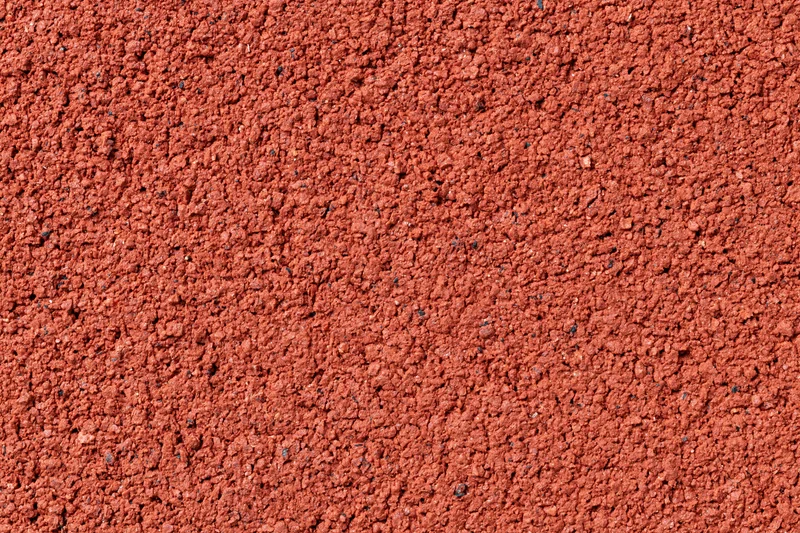 Close-up flat lay of red rubber running track surface filling frame