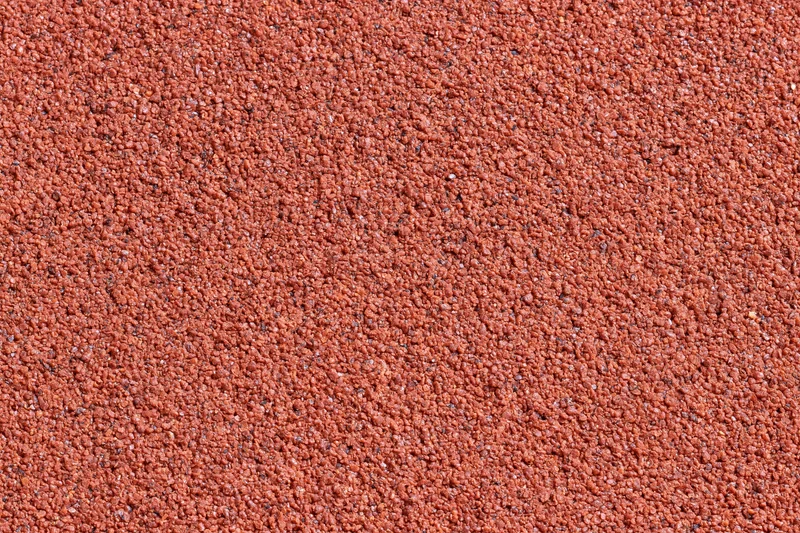 Close-up of red rubber running track surface filling the frame