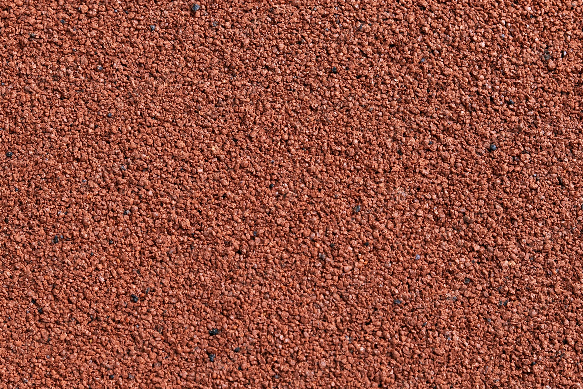 Close-up flat lay of red rubber running track surface filling frame