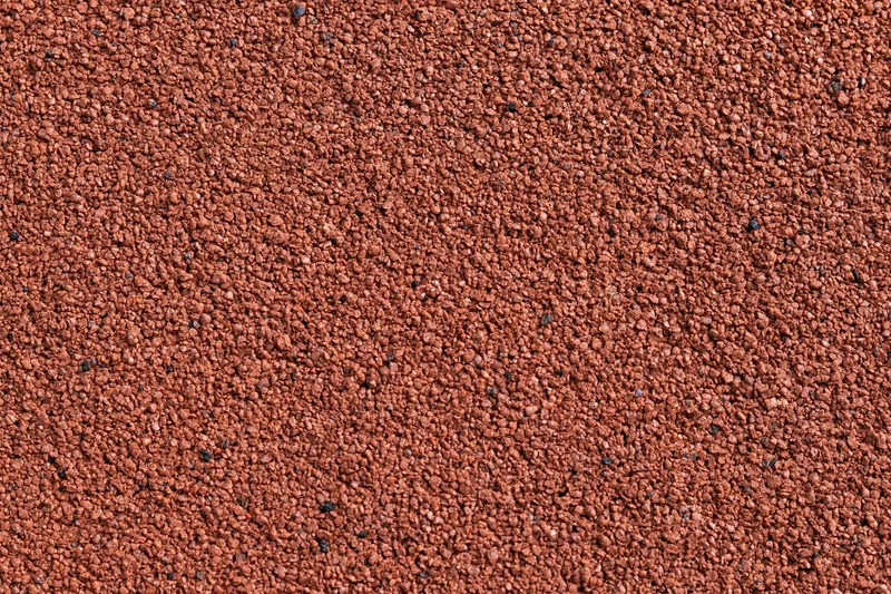 Close-up flat lay of red rubber running track surface filling frame