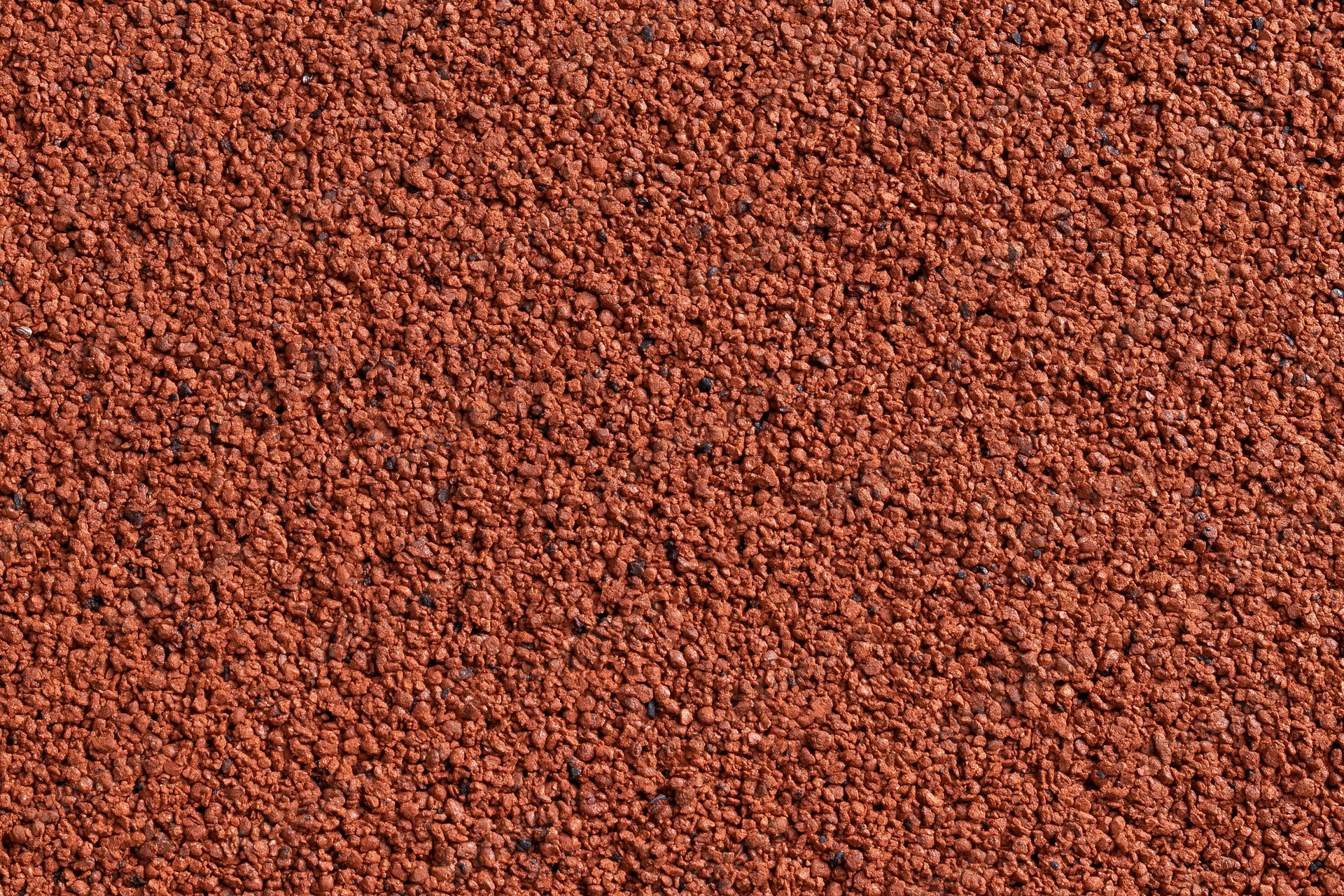 Close-up flat lay of red rubber running track surface filling frame