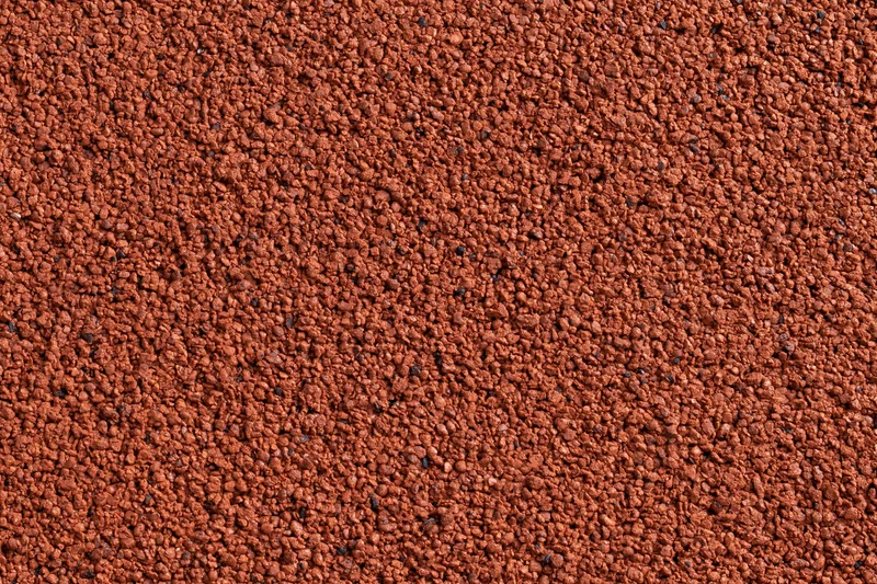 Close-up flat lay of red rubber running track surface filling frame