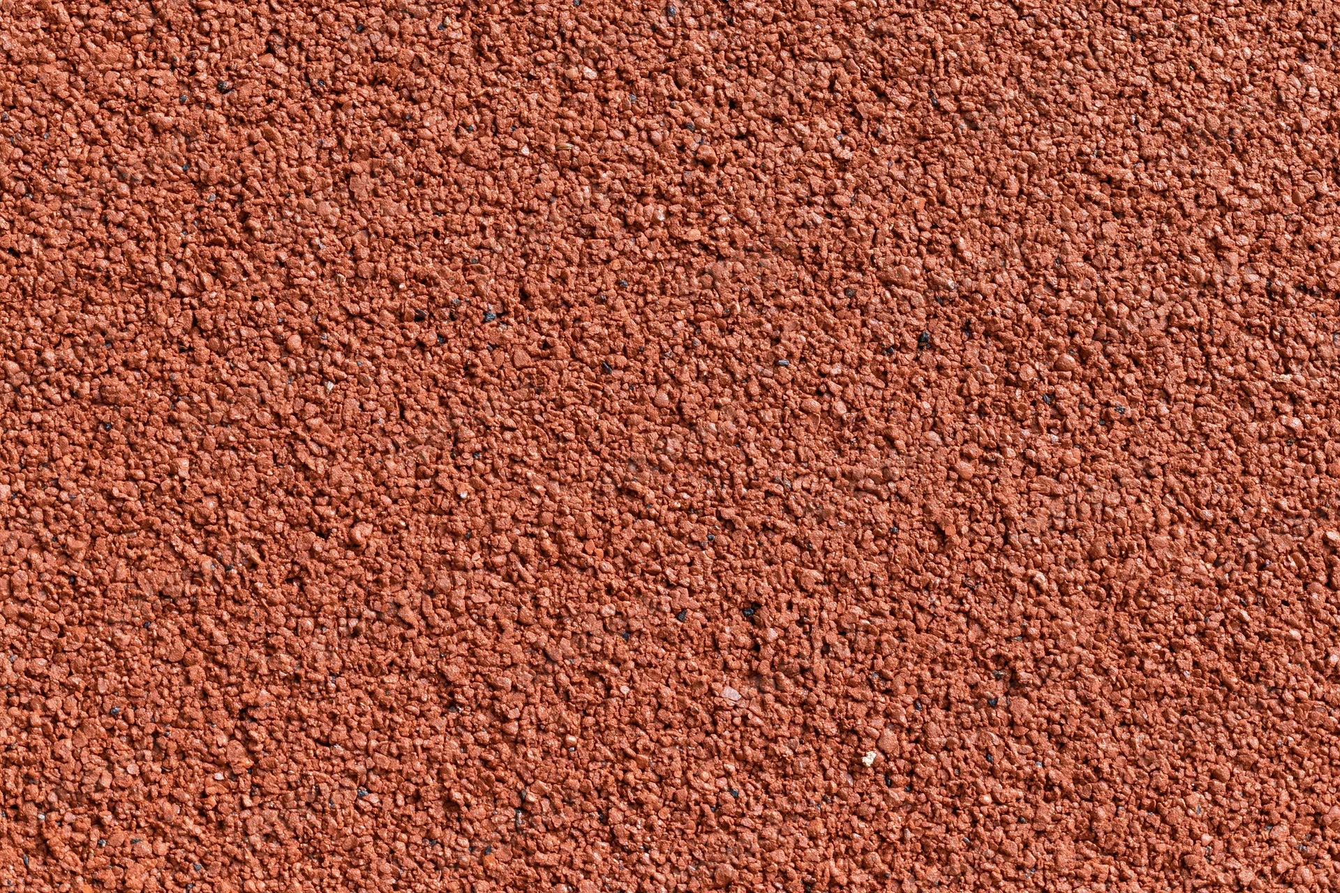 Close-up flat lay of red rubber running track surface filling frame
