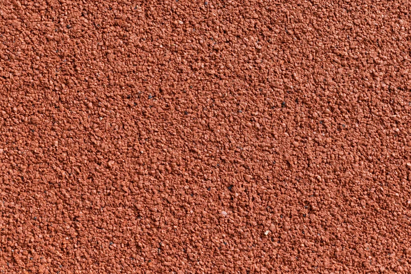 Close-up flat lay of red rubber running track surface filling frame