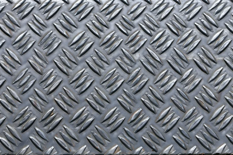 Close-up flat lay of steel diamond plate surface filling the frame