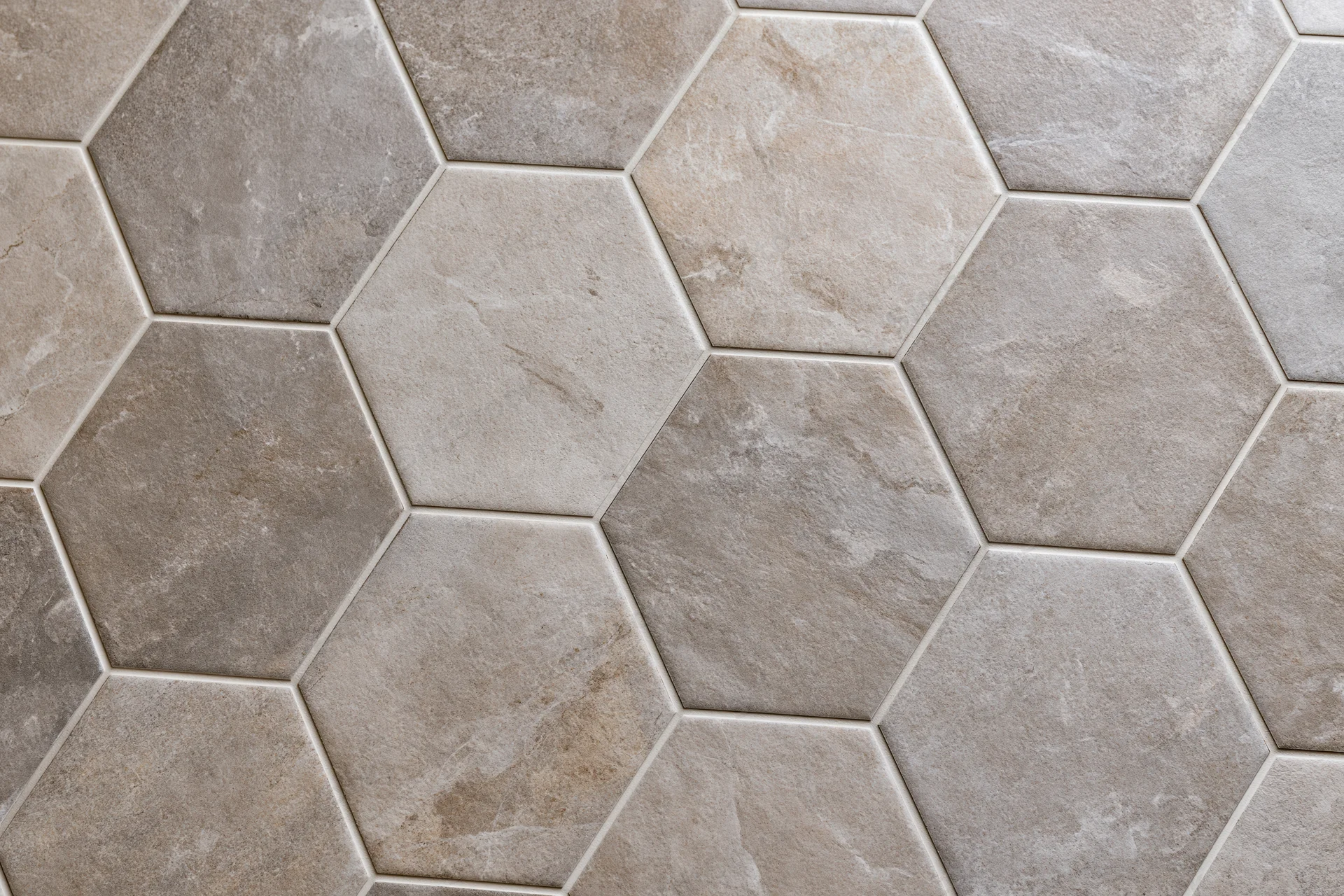 Hexagonal ceramic tiles arranged in a repeating pattern on a floor or wall surface