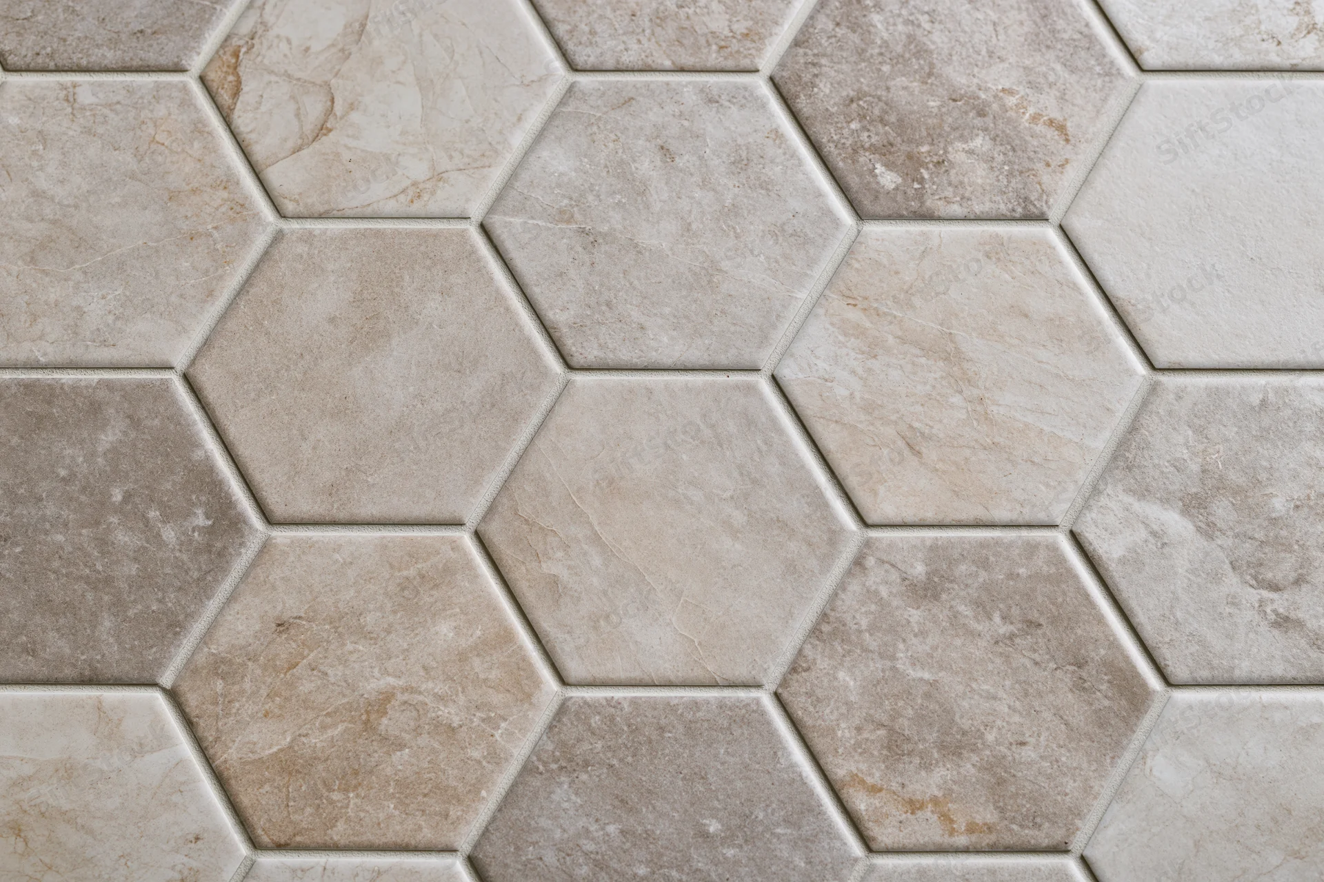 Hexagonal ceramic tiles arranged in a repeating pattern on a floor or wall surface