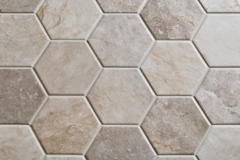 Hexagonal ceramic tiles arranged in a repeating pattern on a floor or wall surface
