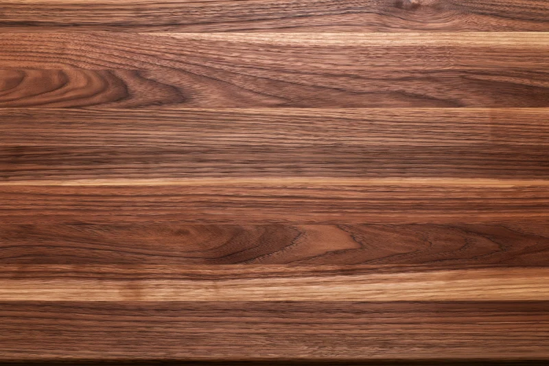 Close-up of a walnut butcher block wood surface arranged horizontally with visible grain and texture