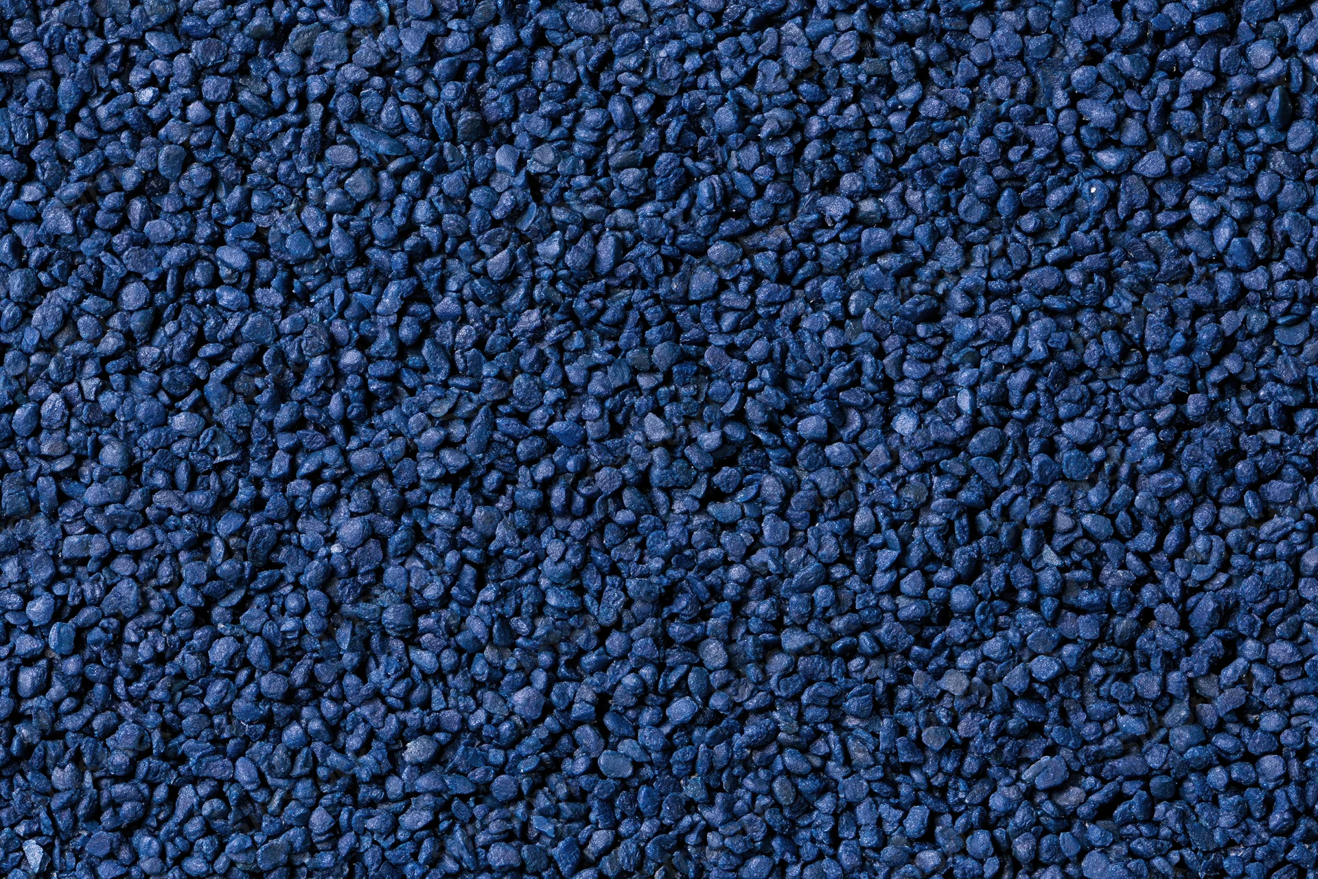Close-up flat lay of blue rubber granules forming a textured surface