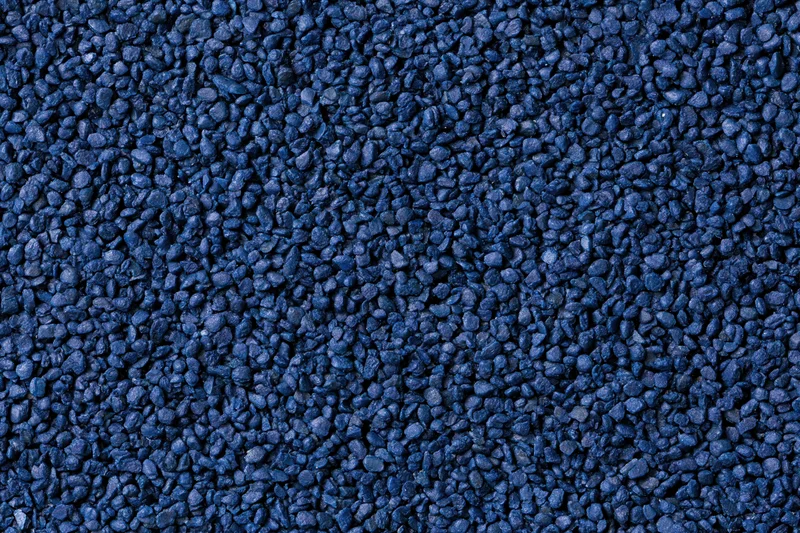 Close-up flat lay of blue rubber granules forming a textured surface