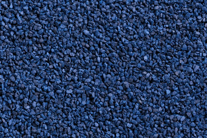 Blue rubber granules arranged in a flat lay close-up surface texture