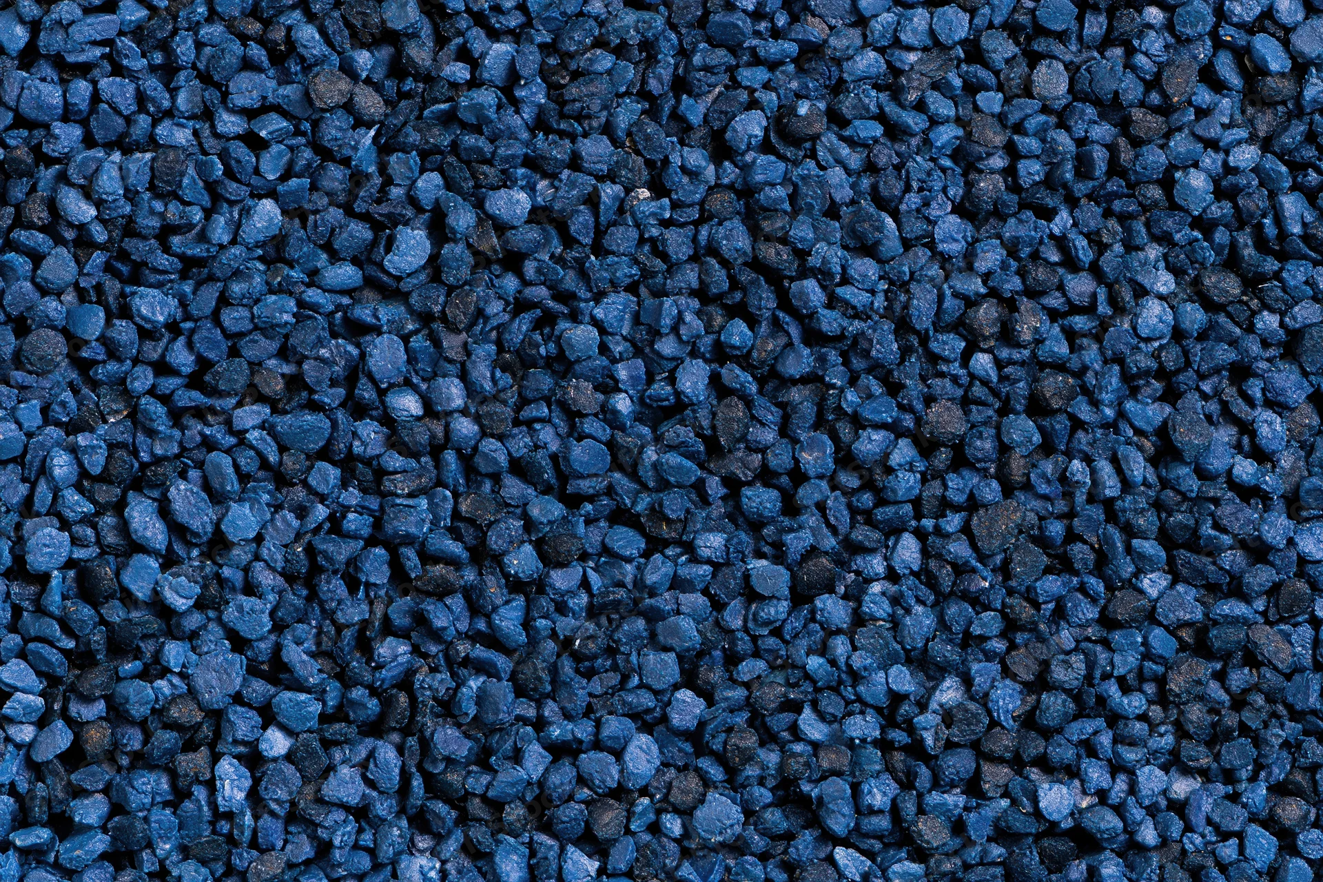 Blue rubber granules arranged in a flat lay close-up surface texture