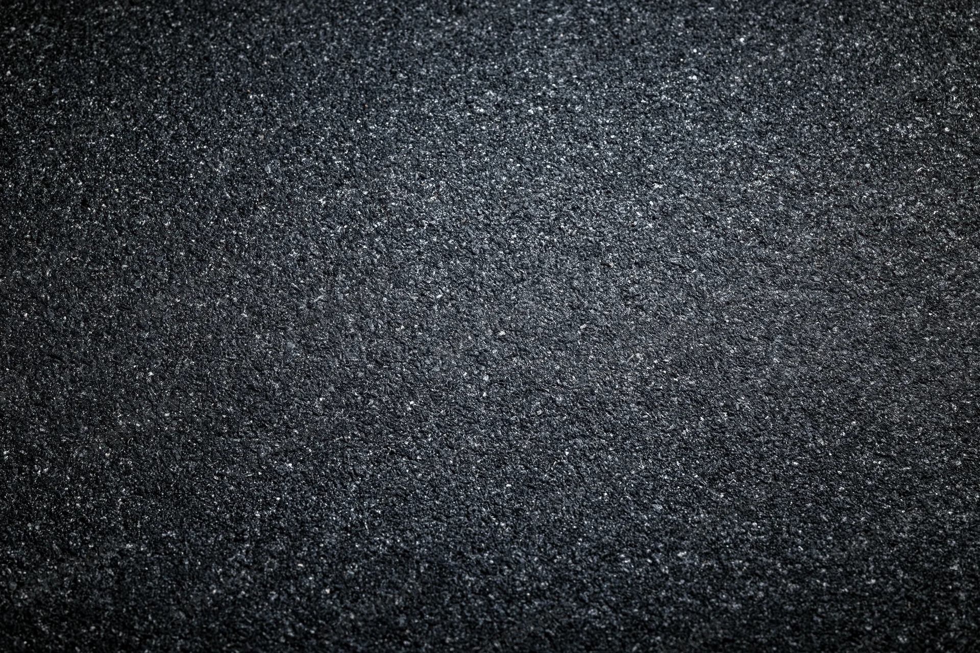 Dark asphalt road surface texture in flat lay closeup view