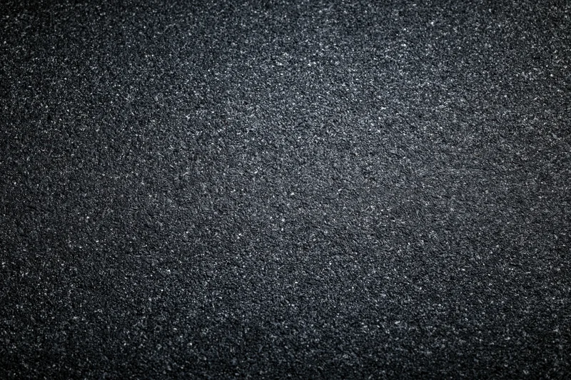 Dark asphalt road surface texture in flat lay closeup view