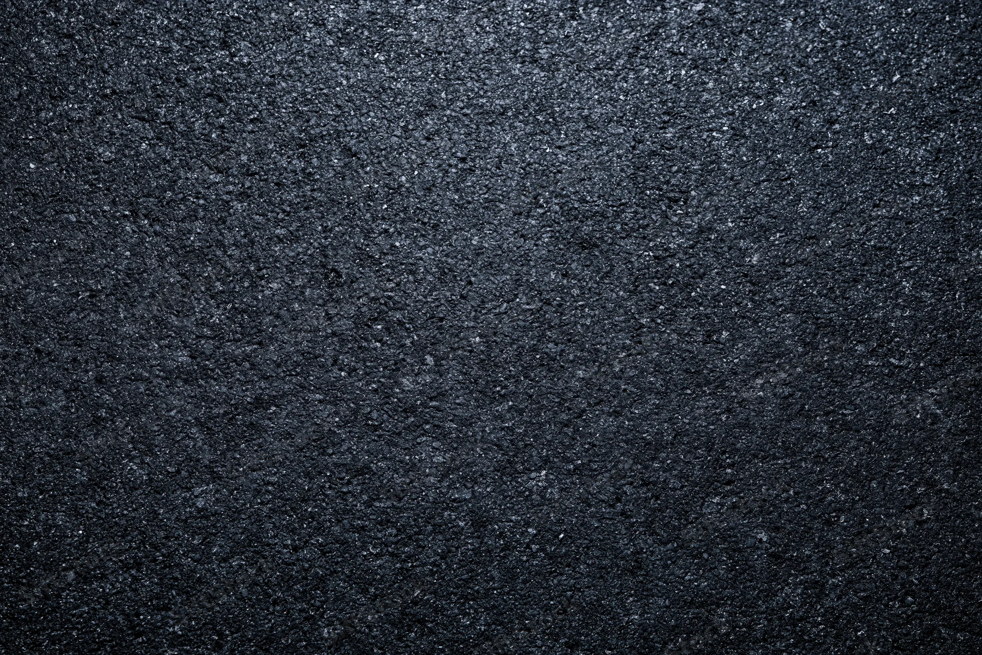 Dark asphalt road surface texture in close-up flat lay view
