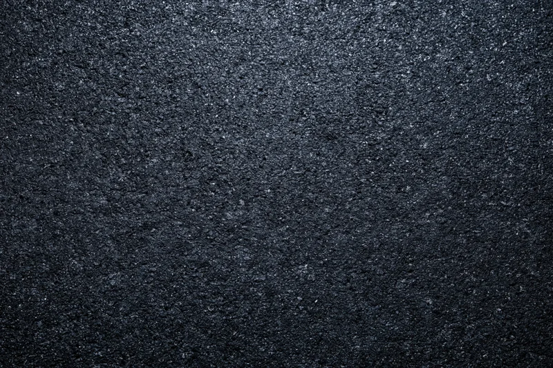 Dark asphalt road surface texture in close-up flat lay view