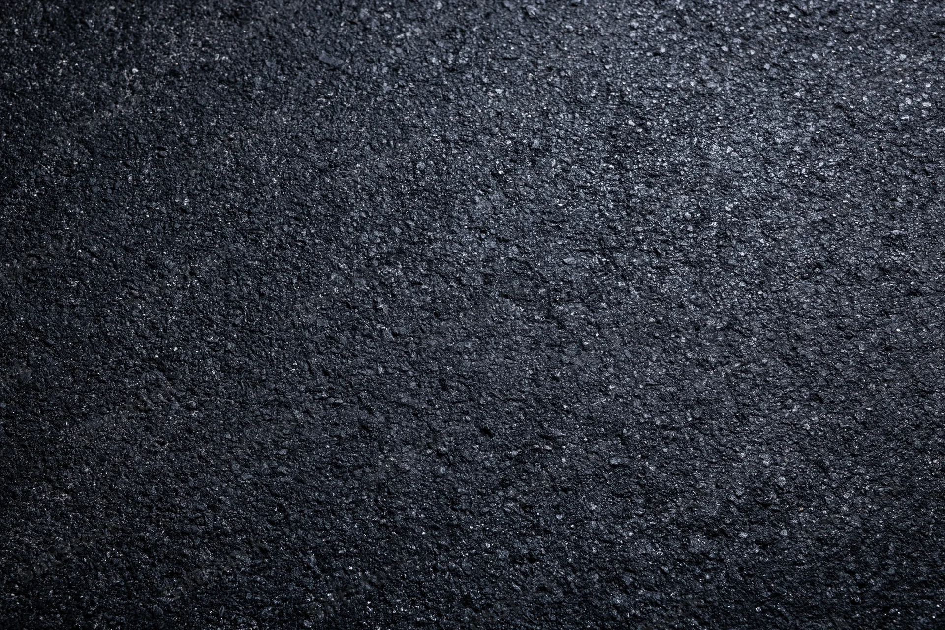 Dark asphalt road surface texture in flat lay closeup view