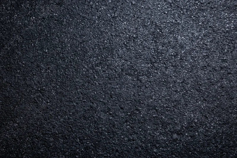 Dark asphalt road surface texture in flat lay closeup view
