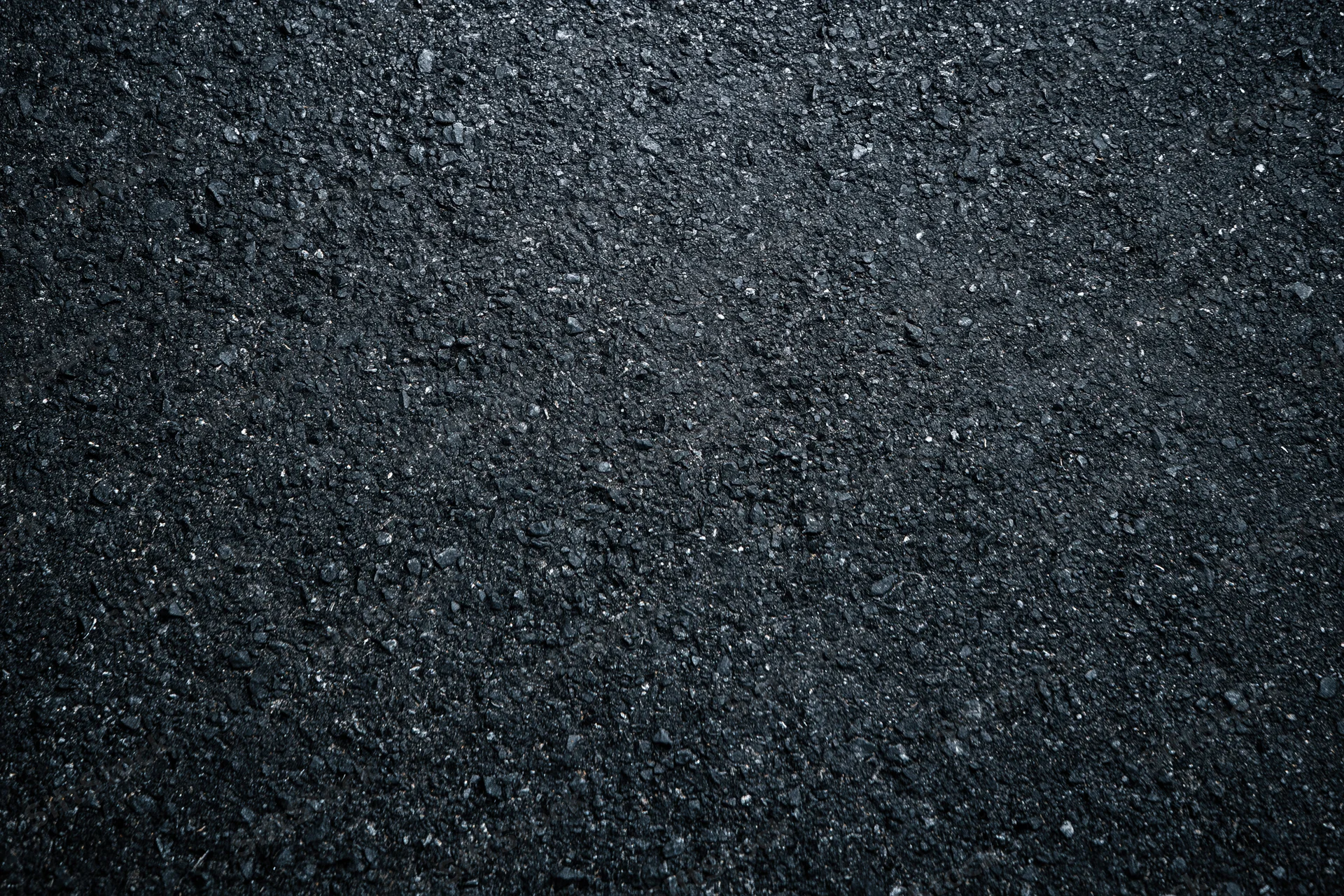 Dark asphalt road surface texture in close-up flat lay view