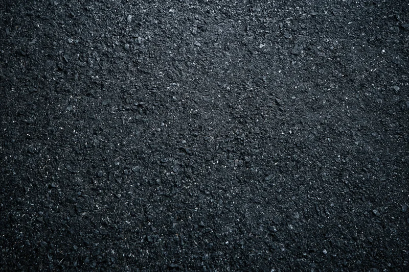 Dark asphalt road surface texture in close-up flat lay view