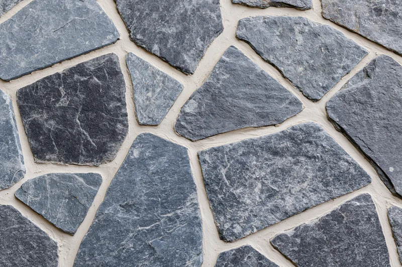Irregular gray flagstones arranged in a mosaic pattern for outdoor pavement