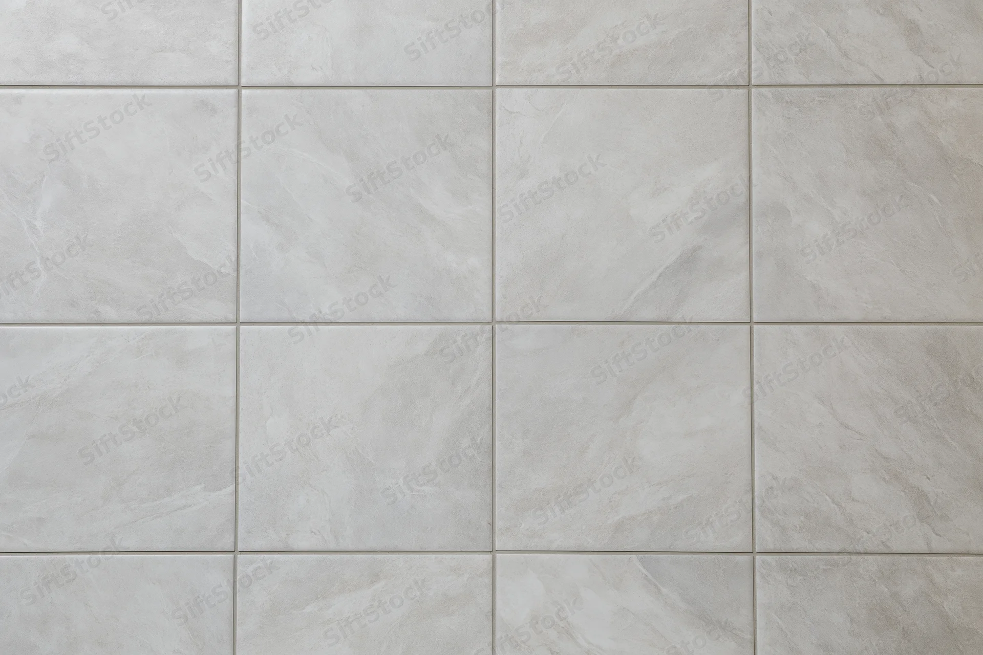 Large-format light grey ceramic floor tiles arranged in a grid pattern for interior flooring