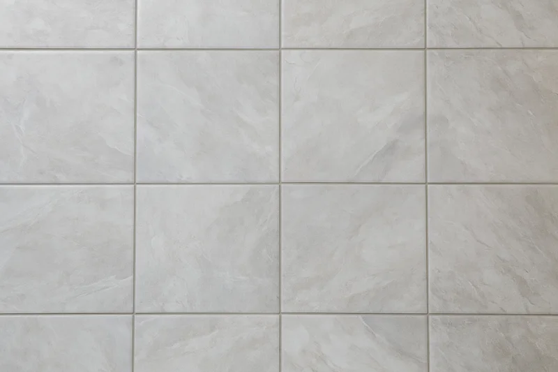 Large-format light grey ceramic floor tiles arranged in a grid pattern for interior flooring